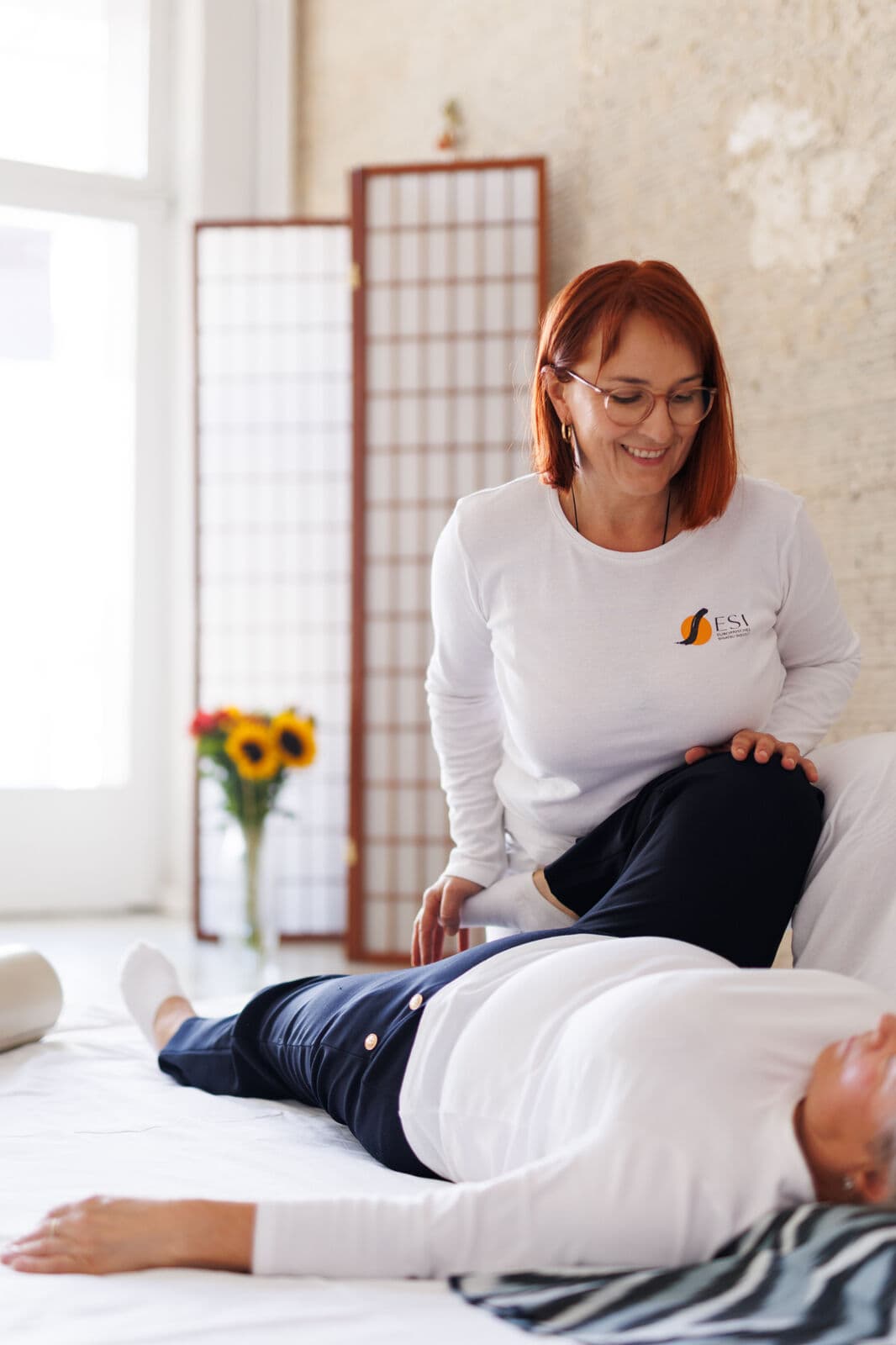 Shiatsu-Sitzung in der Praxis, auf der Matte vor einem Shoji-Paravent