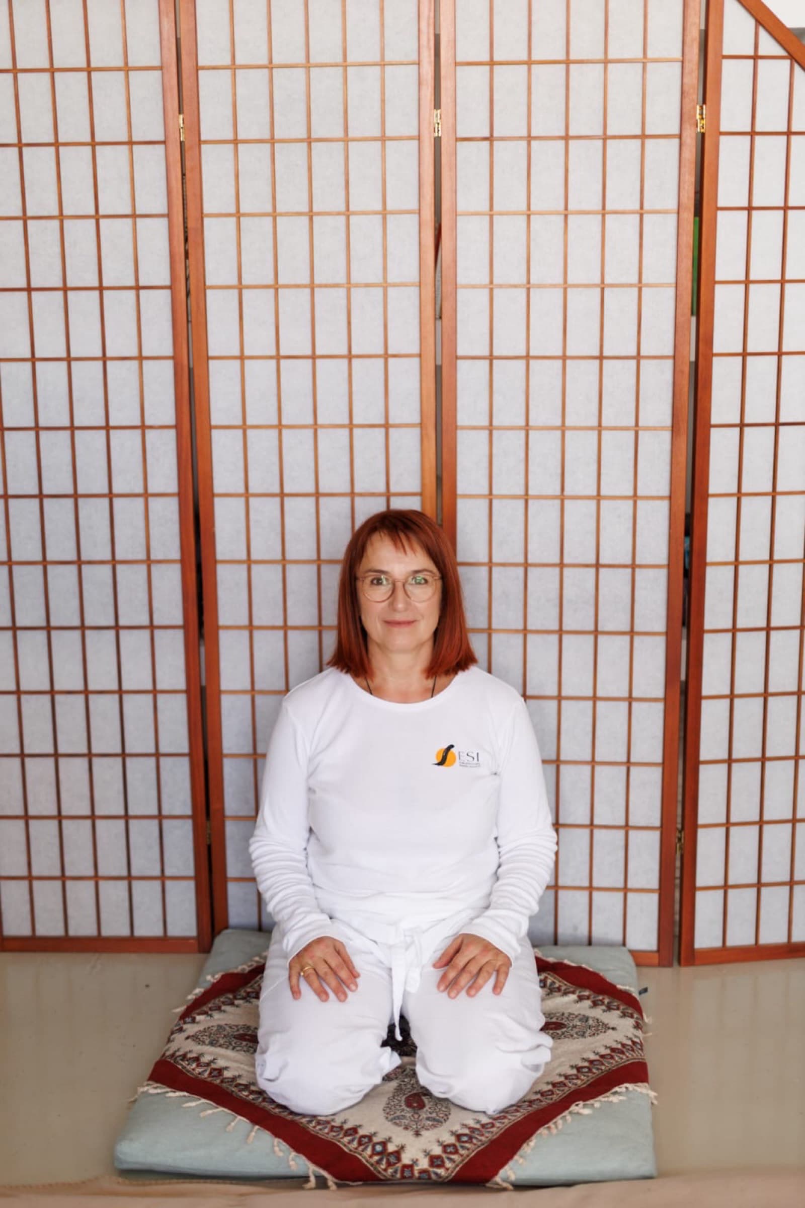 Katarzyna Golenia, Shiatsu-Praktikerin, kniend auf einem Futon vor einem Shoji-Paravent